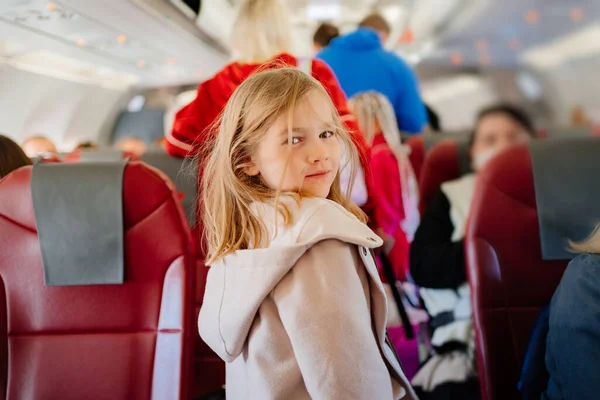 Una niña está en el pasillo del avión. viajar con niños — Foto de Stock