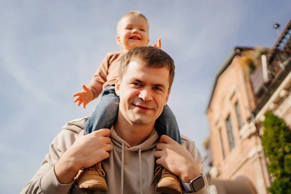 Um pai vira o filho sobre os ombros. jogos e passeios com crianças. — Fotografia de Stock
