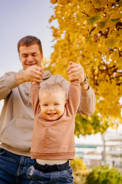 O pai balança e brinca com o filho. jogos e passeios com crianças. — Fotografia de Stock