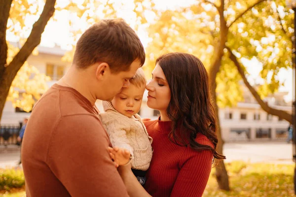 Um retrato de família feliz com uma criança pequena em um passeio de outono. — Fotografia de Stock