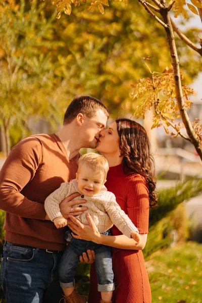 Um retrato de família feliz com uma criança pequena em um passeio de outono. — Fotografia de Stock