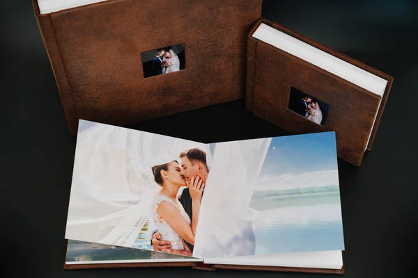 Свадебные фотокниги в коричневой кожаной переплетки с фотографиями на обложке — стоковое фото