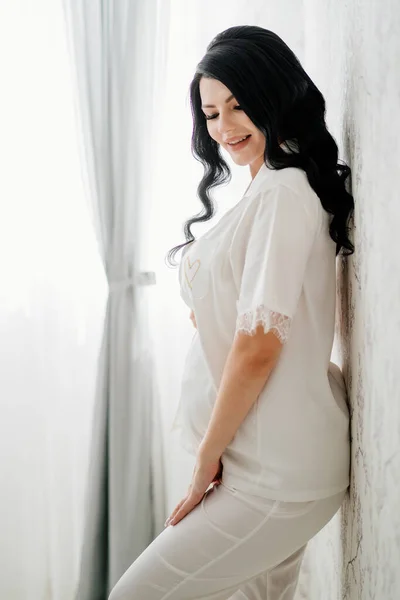 하얀 잠옷을 입은 아름다운 임신 한 신부 갈색 머리. — 스톡 사진