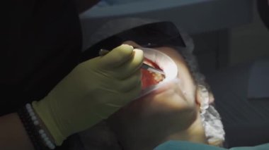 Gerçek. Diş hekimi hastaya bakıcı, diş matkabı ve dolgu malzemesi veriyor.