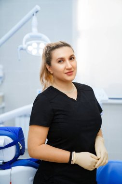 Kliniğin taksisinde iş yerinde siyah üniformalı bir kadın dişçi..