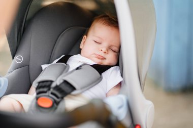 Küçük bir çocuk bebek arabasında bağlı uyuyor.. 