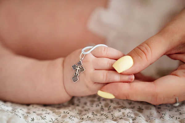 Madre toma la mano de un bebé con una cruz ortodoxa. —  Fotos de Stock