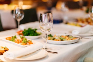 Şenlik masasında boş bir şarap kadehi. Restoranlar için sofra takımı ve evde.
