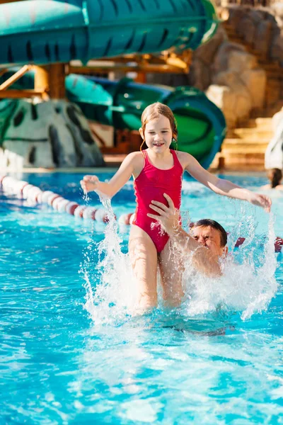 Papá vomita a su hija, se divierten y juegan juntos en la piscina. — Foto de Stock