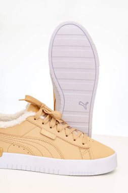 Açık kahverengi kış ayakkabıları Puma beyaz arka planda beyaz tabanlı kürklü..