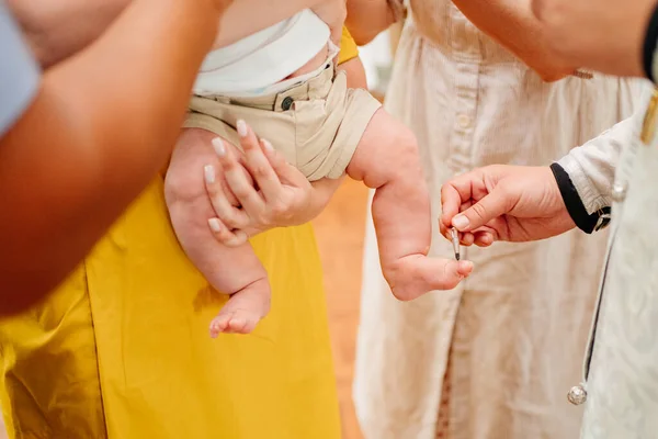 Ben av barnet pojke gör dop vid dopet i kyrkan. — Stockfoto