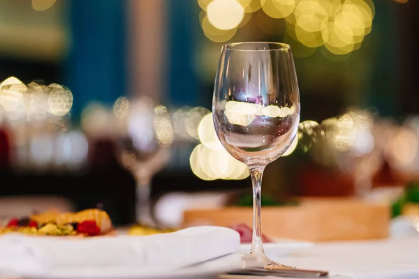 Um copo de vinho vazio na mesa festiva. utensílios de mesa para restaurantes e em casa. — Fotografia de Stock