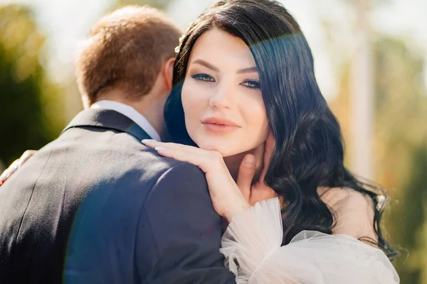 De bruidegom knuffelt de bruid zachtjes. Gelukkig pasgetrouwden. romantische relaties. — Stockfoto