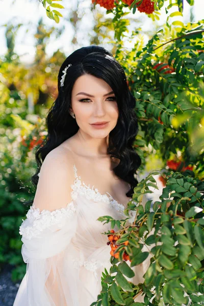 Приваблива брюнетка наречена у весільній сукні в парку з суничними деревами . — стокове фото