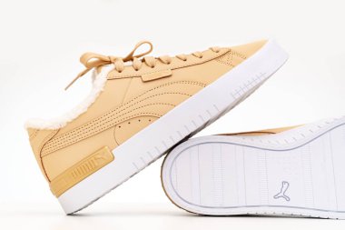 Açık kahverengi kış ayakkabıları Puma beyaz arka planda beyaz tabanlı kürklü..