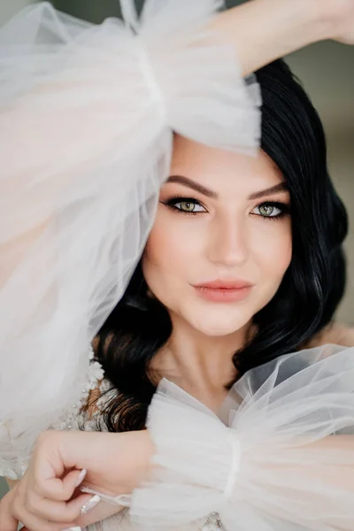Närbild. vacker brunett brud i vit klänning med transparent puffy ärmar — Stockfoto