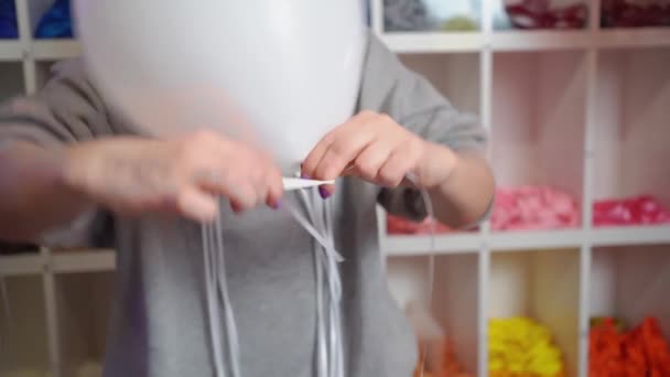 Bir kadın şişirilmiş helyum beyaz balonuna kurdele bağlar. — Stok video