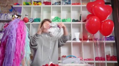 Kadın akrobasi tasarımcısı şişmeden önce düz şeffaf bir balon tutuyor.