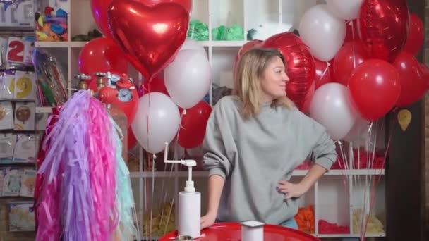 Kvinnlig Flygdesigner Med Sammansättning Vita Röda Folieballonger Form Ett Hjärta — Stockvideo