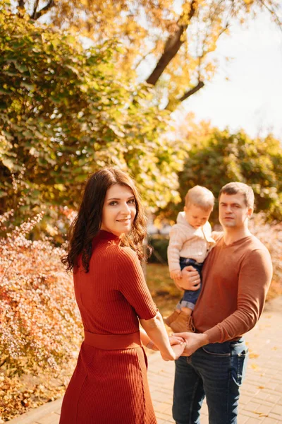 Uma família com uma criança pequena em um passeio de outono ao redor da cidade. — Fotografia de Stock