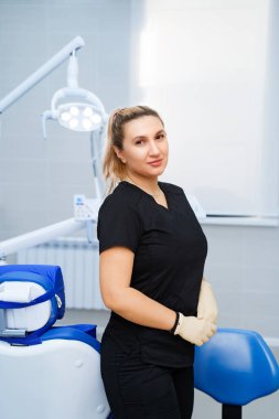 Kliniğin taksisinde iş yerinde siyah üniformalı bir kadın dişçi..