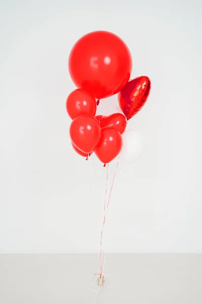 Red and white balloons in shape of ball and heart on white background. — Stock Photo, Image