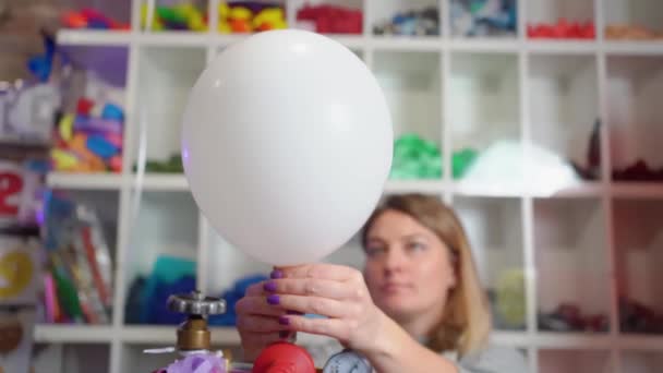 Uma mulher infla de hélio de um balão branco. — Vídeo de Stock