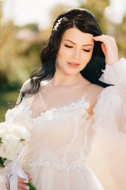 Açık havada bir buket çiçekli esmer gelin. 