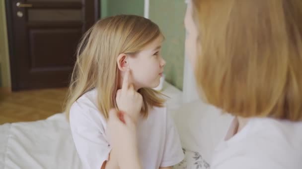 Dcera si stěžuje na bolest v uchu a matka ji zkoumá. — Stock video