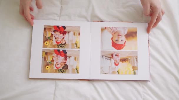 Las manos se desplazan a través de páginas de fotolibro sobre fondo blanco. sesión de fotos familiares — Vídeos de Stock