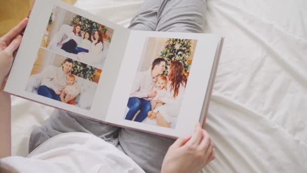 Händer bläddra igenom sidor av fotobok. familj fotografering — Stockvideo