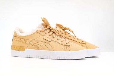 Açık kahverengi kış ayakkabıları Puma beyaz arka planda kürklü.