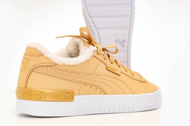 Açık kahverengi kış ayakkabıları Puma beyaz arka planda beyaz tabanlı kürklü..