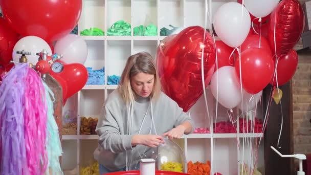 Cravates femme avec un ruban un ballon rond transparent avec des plumes blanches à l'intérieur. — Video