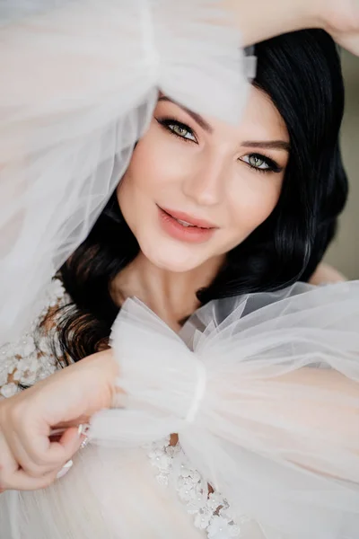 Primer plano. hermosa novia morena en vestido blanco con mangas hinchadas transparentes — Foto de Stock