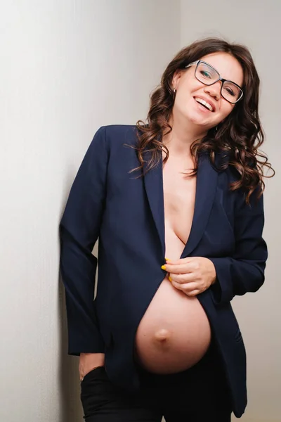 Vacker gravid kvinna i glasögon och svart jacka med bara bröst och mage — Stockfoto