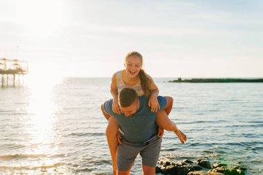 Babası deniz kıyısında kızına biniyor.. 
