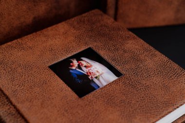 Kahverengi deri kaplamalı düğün fotoğrafları ve kapağında fotoğraflar.