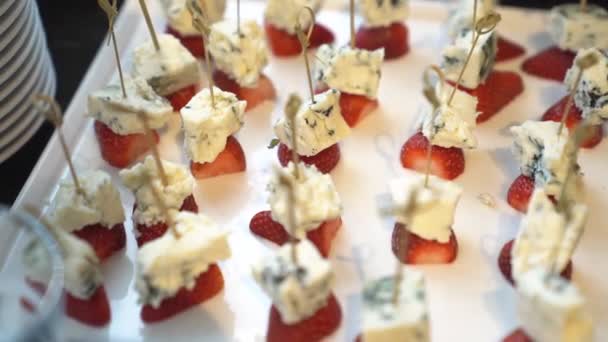 Cheese with mold and strawberries on skewers. — Stock Video