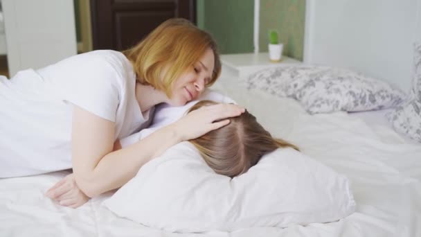 Mama îmbrățișează și alină fiica ei supărat mic la domiciliu. — Videoclip de stoc