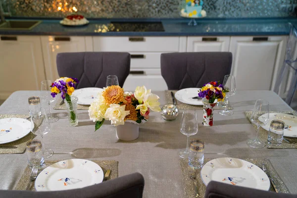 Mesa de comedor servida con utensilios y flores en el comedor. — Foto de Stock