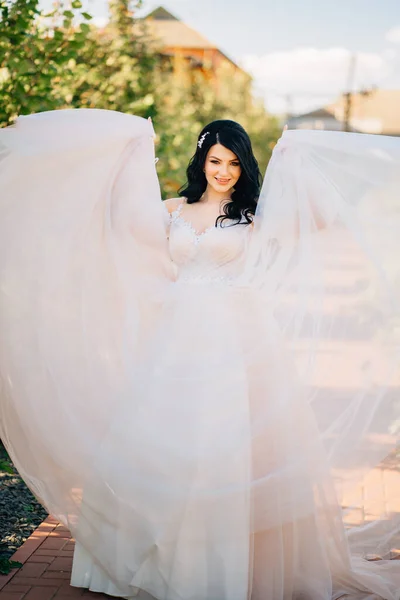 Bela noiva em vestido de noiva no parque. tecido transparente fino para vestido. — Fotografia de Stock