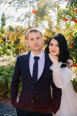 Gelin ve damat parkta bir çalı çırpının yanında durun.. 