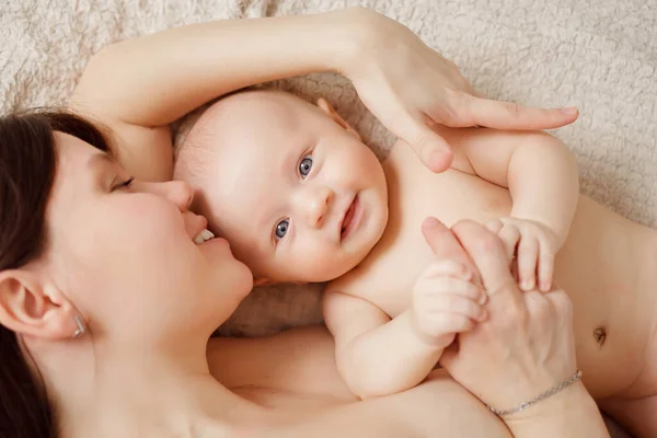 Una madre desnuda y el bebé en la cama. salud materna e infantil. — Foto de Stock