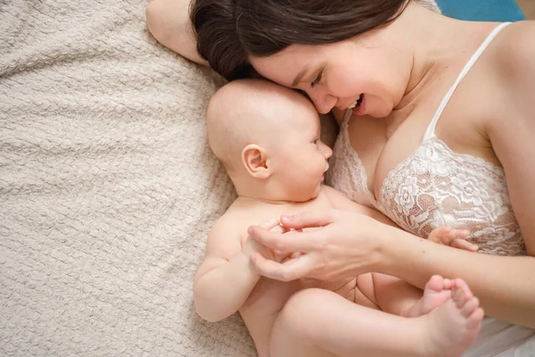 Una madre y el bebé en la cama. salud materna e infantil. —  Fotos de Stock