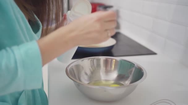 En kvinna bereder en omelett och saltar äggen i en skål. — Stockvideo
