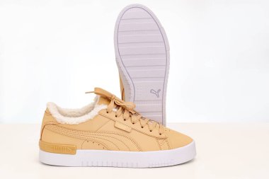 Açık kahverengi kış ayakkabıları Puma beyaz arka planda beyaz tabanlı kürklü..