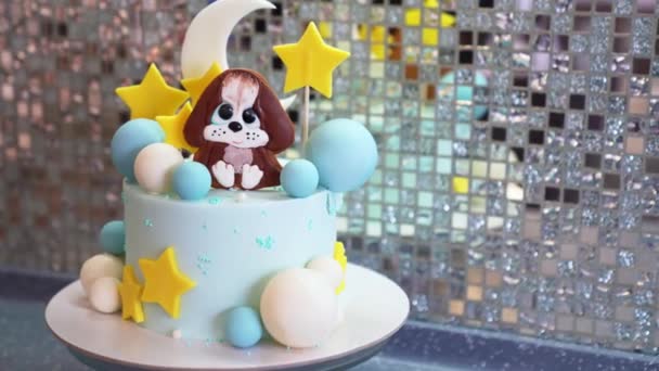 Голубой торт украшен шариками, звездами и щенком из мастики и шоколада. — стоковое видео