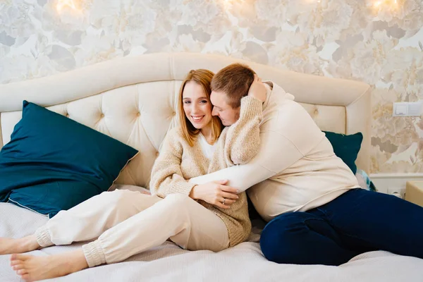 A happy and loving couple hugs on the bed — Stock Photo, Image