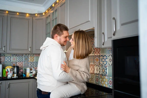 Счастливая и любящая пара валяет дурака и обнимается дома на кухне — стоковое фото